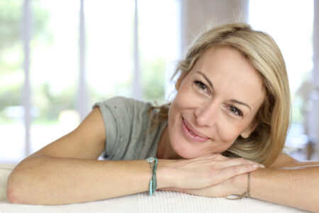 Happy woman leaning on a sofa