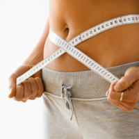 Woman holding a measuring tape around her waist