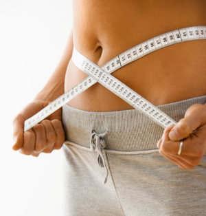 Woman holding a measuring tape around her waist