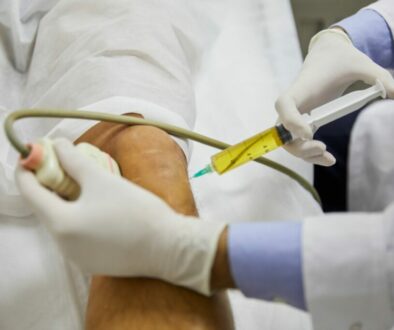 Doctor injecting patient in knee with Stem Cell Therapy