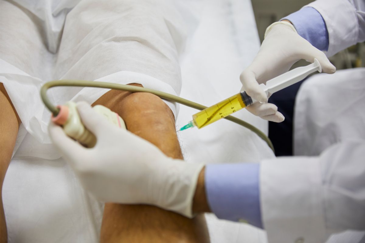 Doctor injecting patient in knee with Stem Cell Therapy