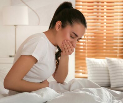 Woman with Leaky Gut Syndrome holding stomach in bed