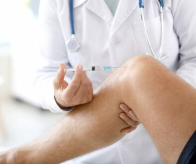 Doctor giving hyaluronic gel injection for knee pain