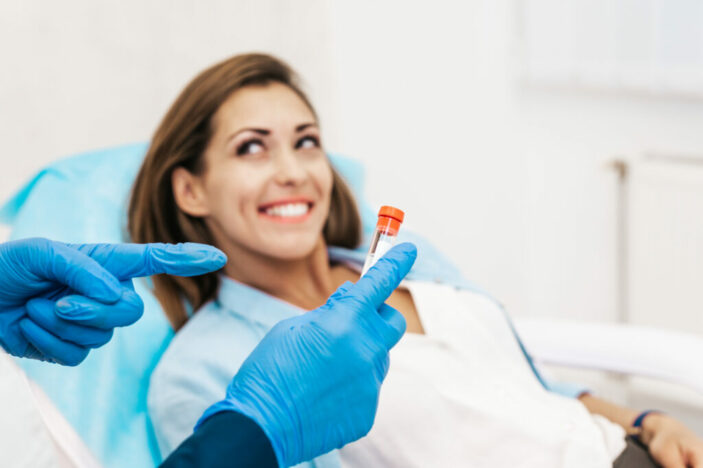 A woman smiles as doctor explains Platelet rich plasma ( PRP) therapy process.