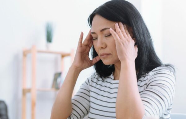 Woman holding her head with a headache